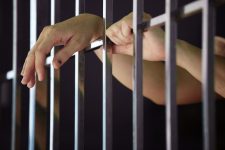 Woman's hands on cell door