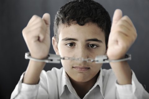 Young boy in handcuffs
