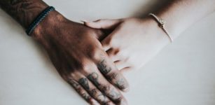 Black and white hands embrace