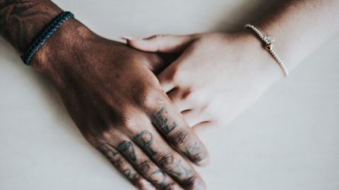Black and white hands embrace