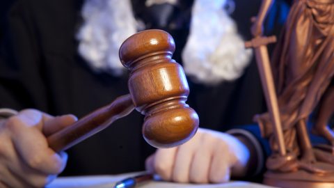 Judge wearing wig using gavel