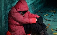 Homeless person wearing red jacket