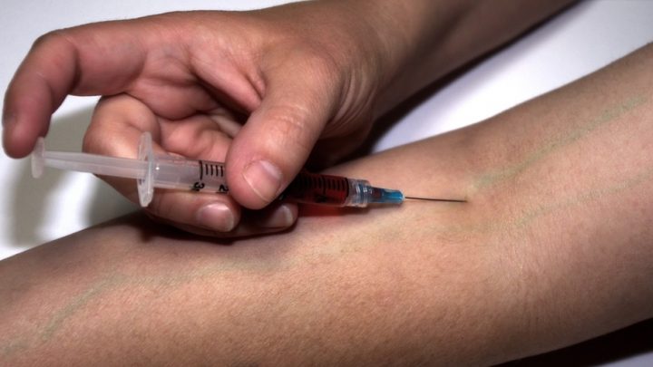 Injection of drug heroin into arm