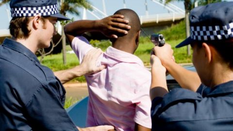 Police pointing gun at motorist