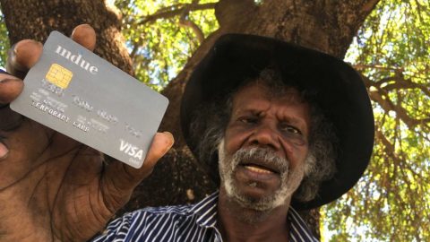 Man displaying a cashless debit card