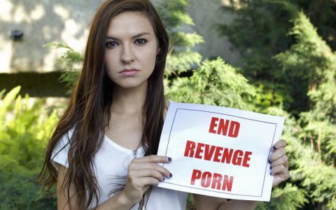 Woman showing end revenge porn sign