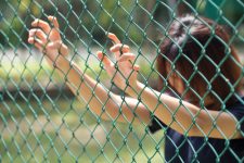 Woman behind fence