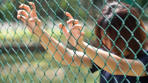 Woman behind fence