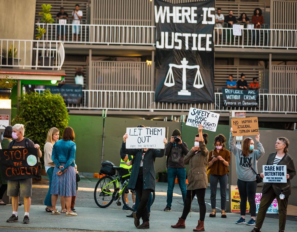 Members of the community blockade standing before the daily balcony protest of detainees. Photo supplied by Refugee Solidarity Brisbane/Meanjin