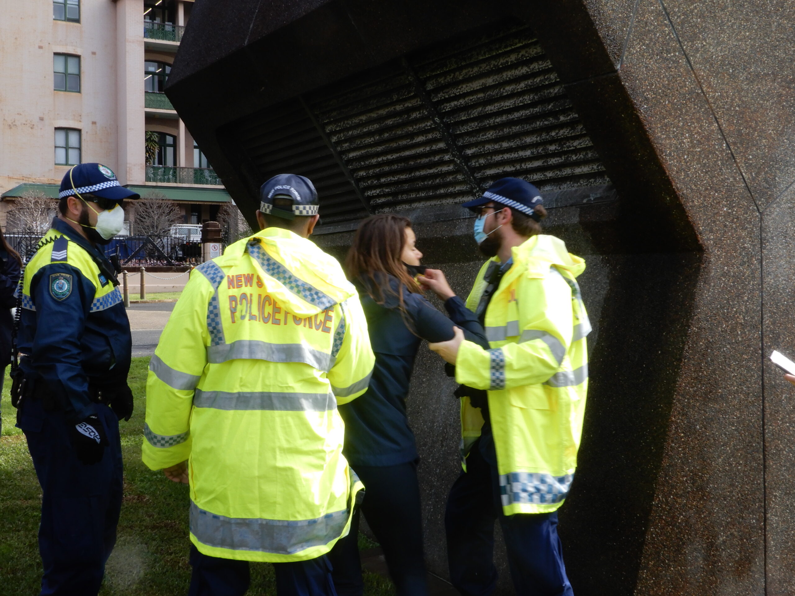 Young woman with megaphone is detained by police