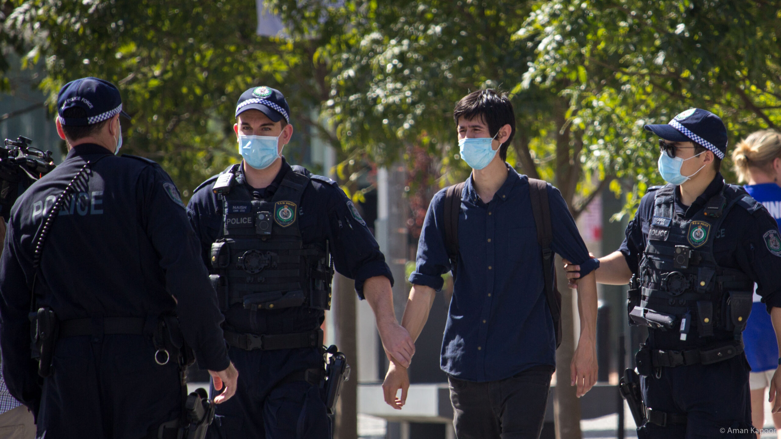 Activist Adam Adelpour is taken into custody. Photo credit Aman Kapoo