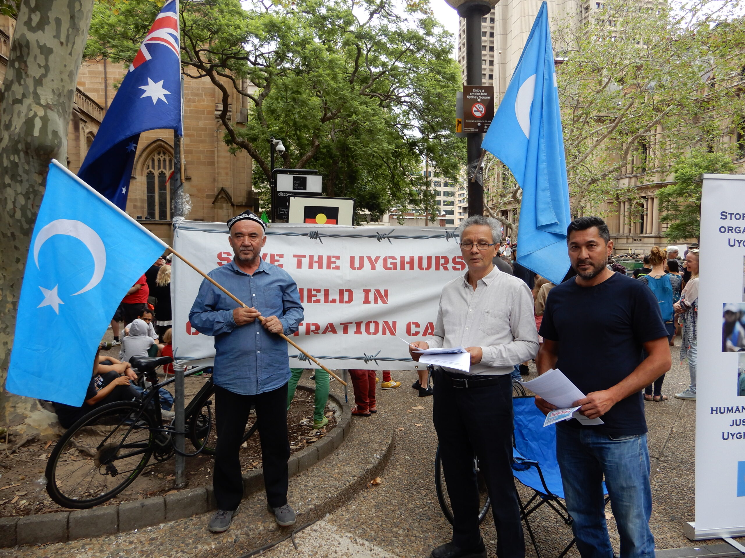 Talgat Abbas (right) and other Uyghur locals campaigning at Sydney Town Hall