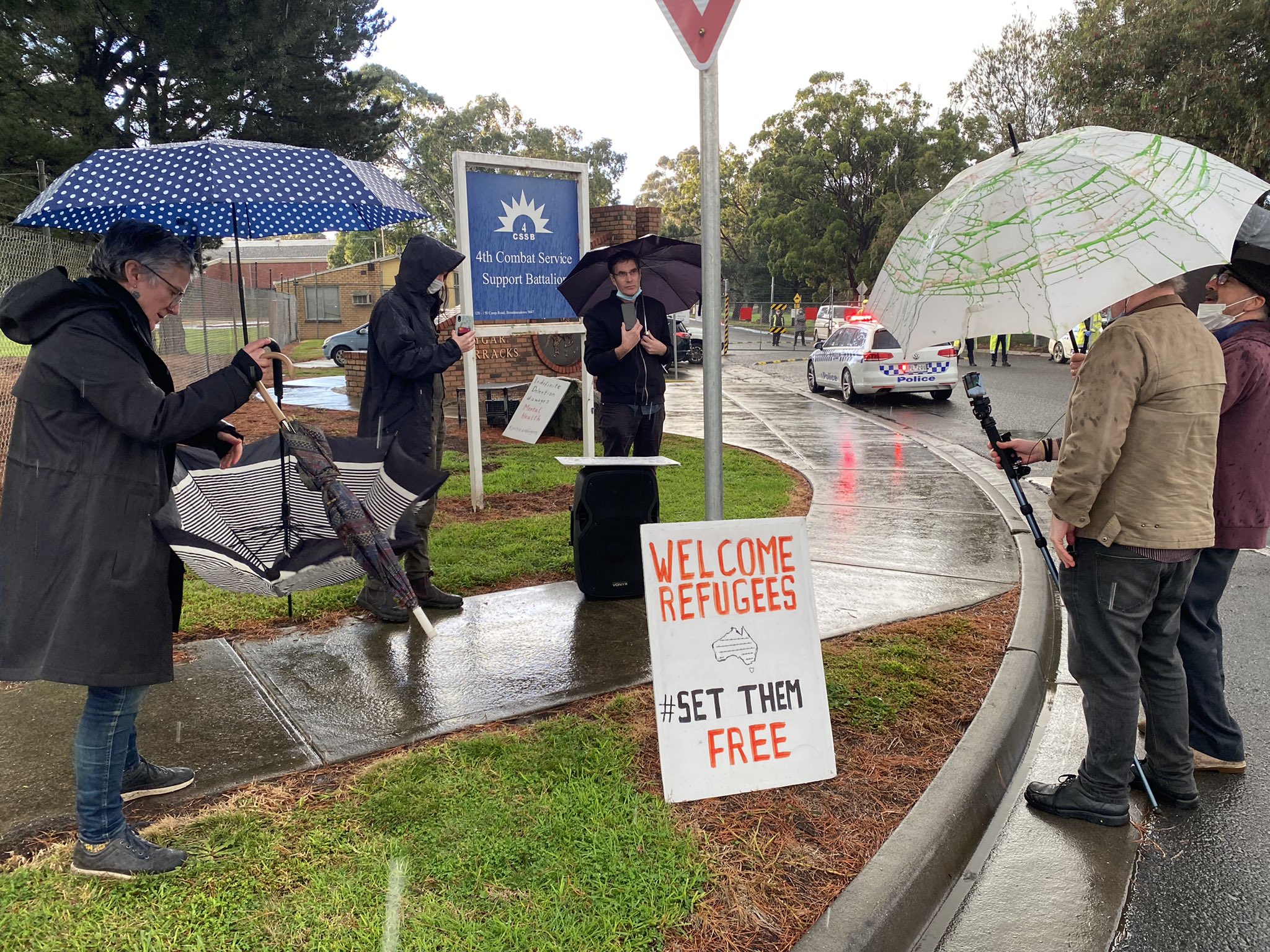 Refugee Action Collective rallying in support of hunger strikers outside the Broadmeadow MITA facility on 25 June. Chris Breen is at the centre underneath a black umbrella. Image supplied by Refuge