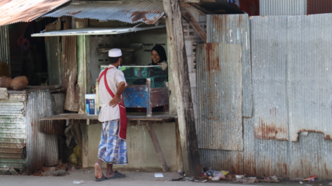 A man buys paan, betel nut, in the Muslim residential area