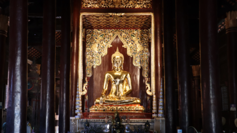 A golden buddha against a teak backdrop in Chiang Mai’s old city