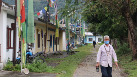 A local man strolls beside a row of Tibetan refugee homes