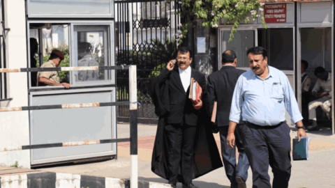 An advocate sporting a black robe out the front of the Guwahati High Court