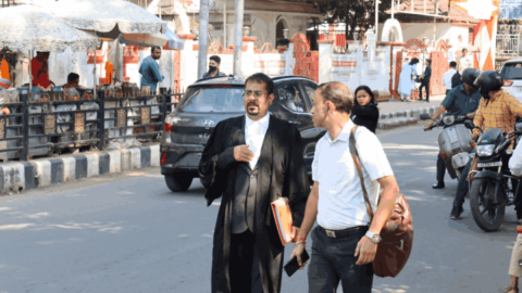 An advocate chats with his client pre-hearing