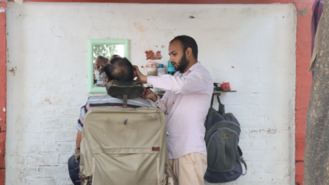 Getting a quiet shave in a side street at an open-air barber shop