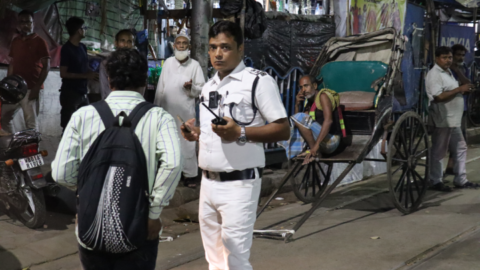 A traffic police officer looks on as his team ensures the roads ahead are cleared for the procession