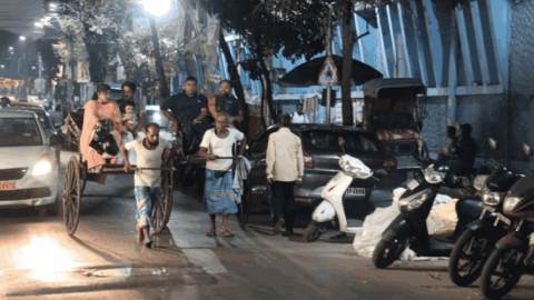 A young rickshaw wallah overtakes an older one, as both carry heavy loads