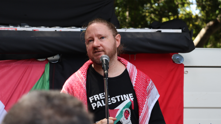Palestine Action Group spokesperson Josh Lees reminded the crowd that a coalition of social justice groups are challenging the Minns government’s blanket protest ban laws Palestine Action Group spokesperson Josh Lees reminded the crowd that a coalition of social justice groups are challenging the Minns government’s blanket protest ban laws