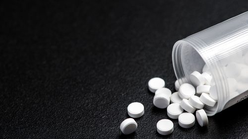 White pills spilling out of bottle