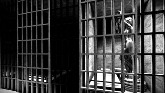Justice statue behind bars